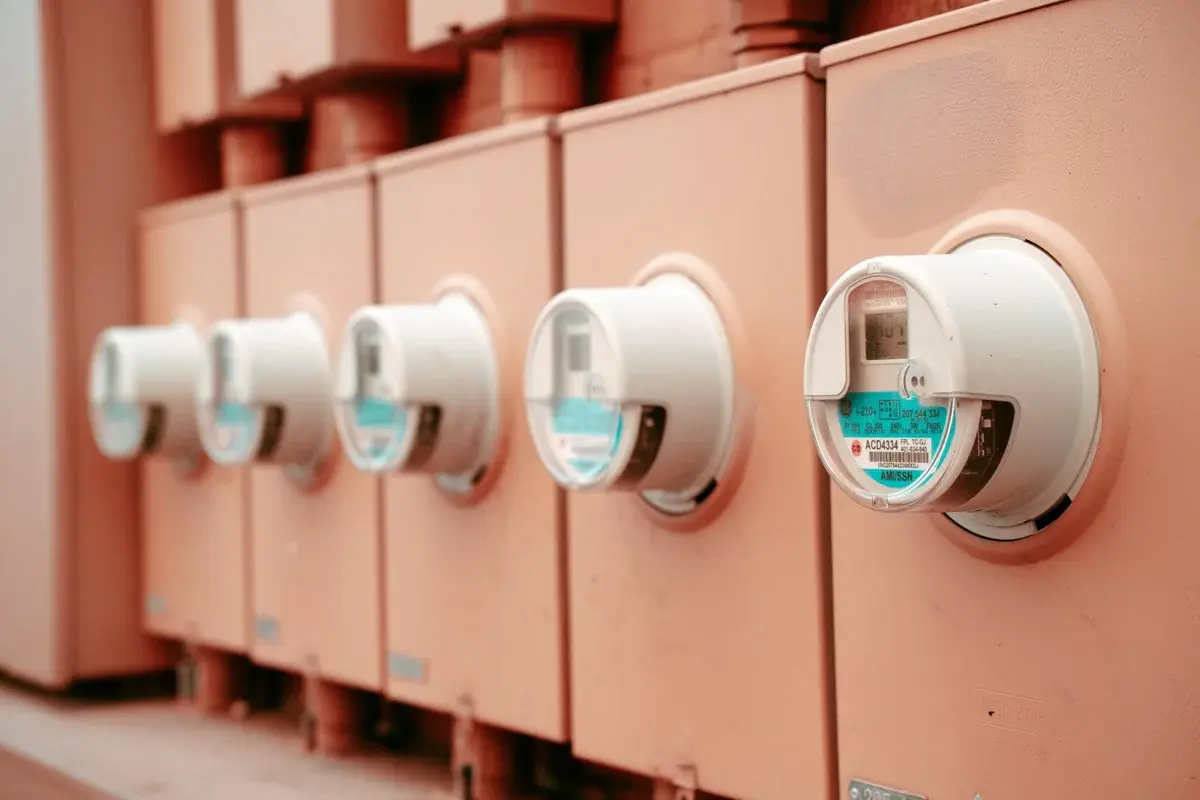 Row of industrial electric meters mounted on a wall.