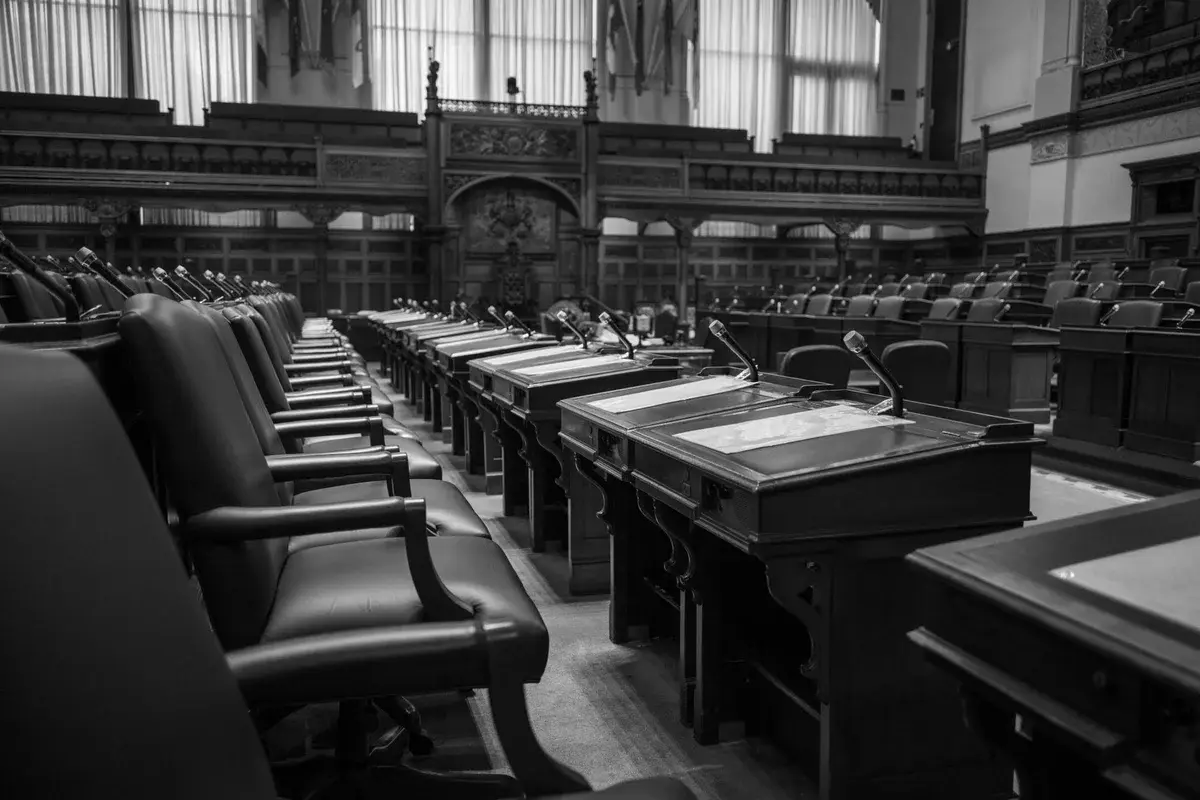 empty seats and desks in a traditional legislative chamber