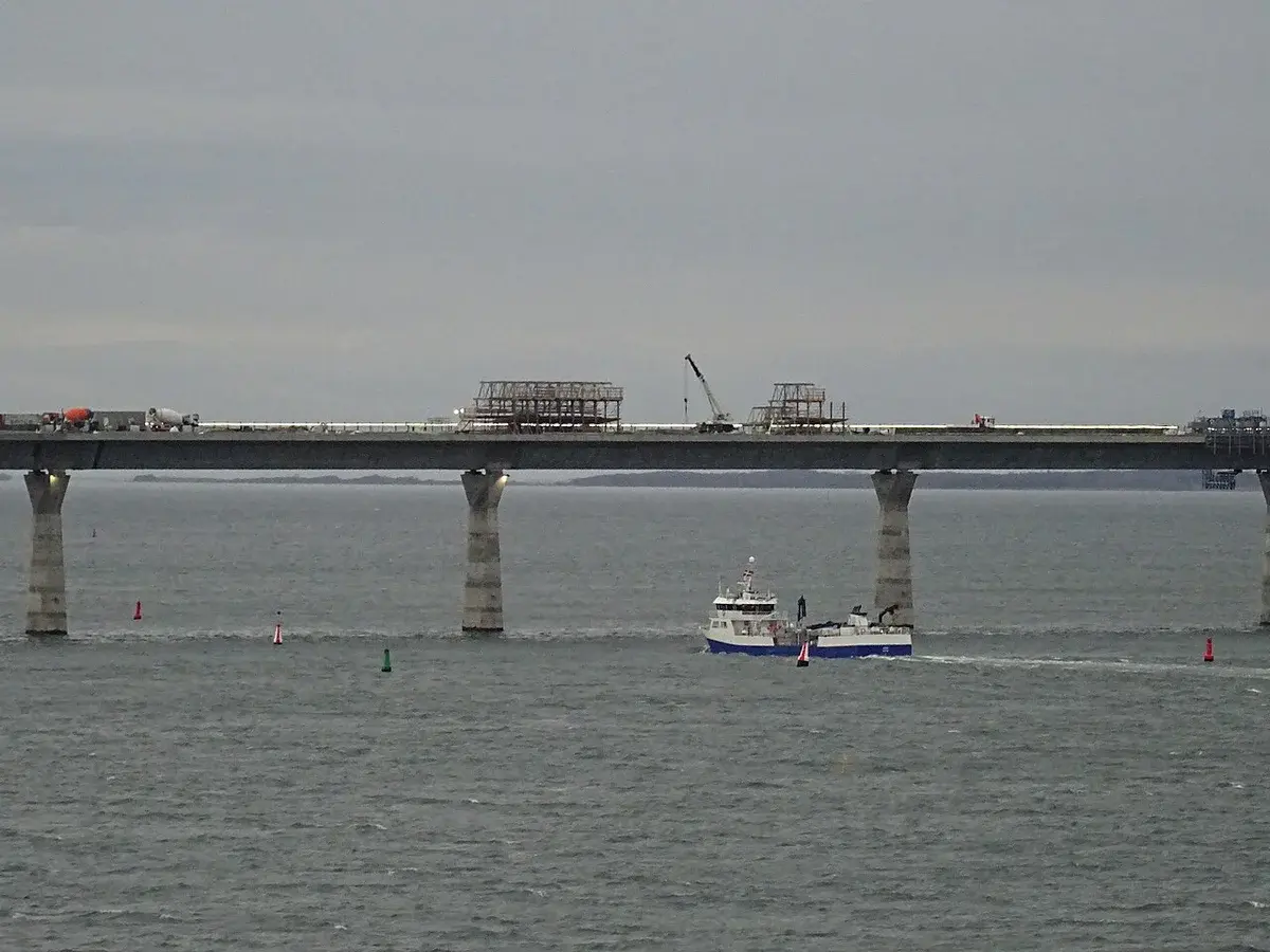 A work boat passes beneath the Storstrøm Bridge construction site in Denmark.