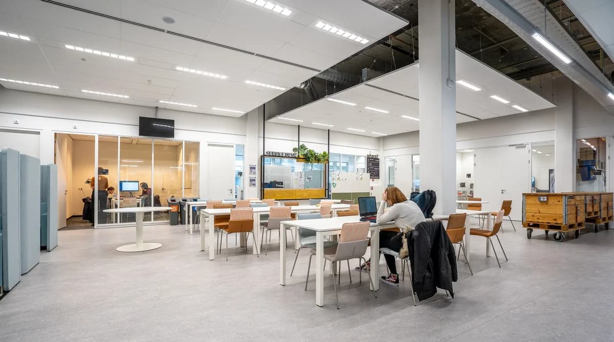 Bright modern office canteen with tables and people working