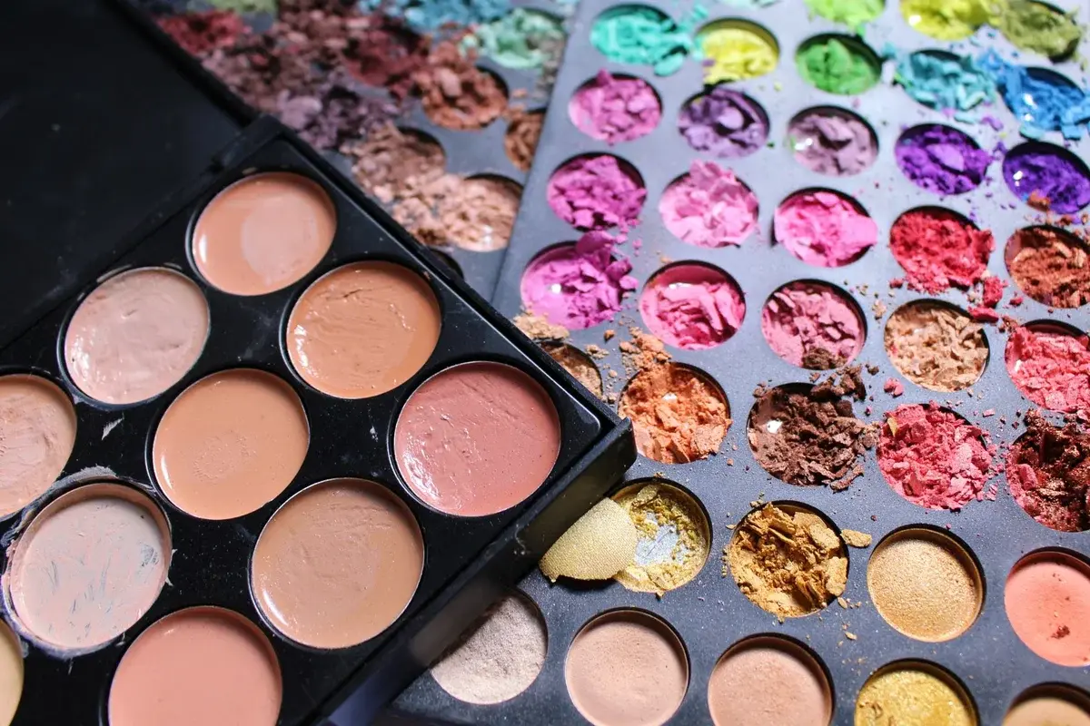 Close-up of makeup palettes with crushed colorful eyeshadow pigments.