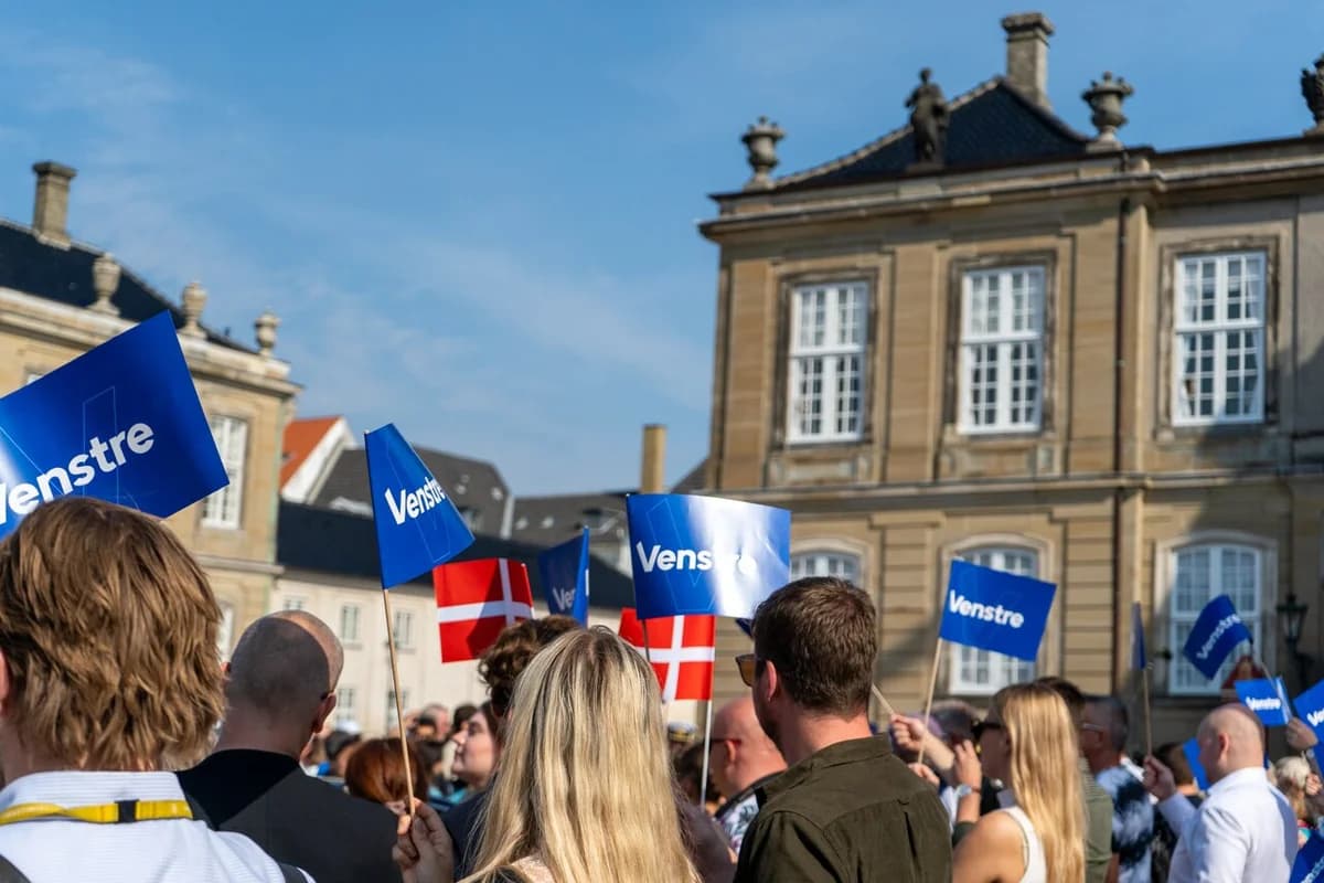 Crowd waving Venstre party flags and Danish flags at Amalienborg Palace Square.