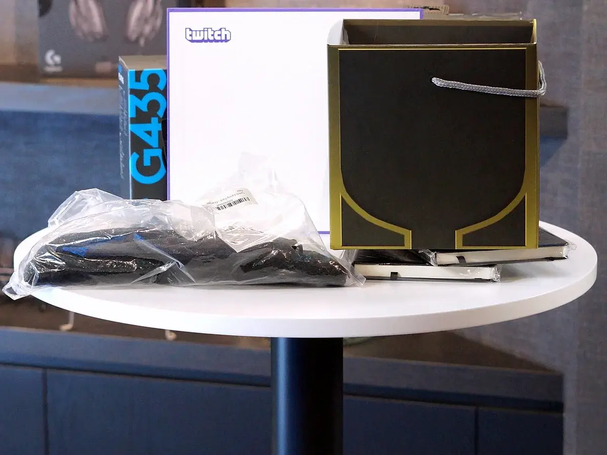 Twitch merchandise and prizes displayed on a table at a live event.