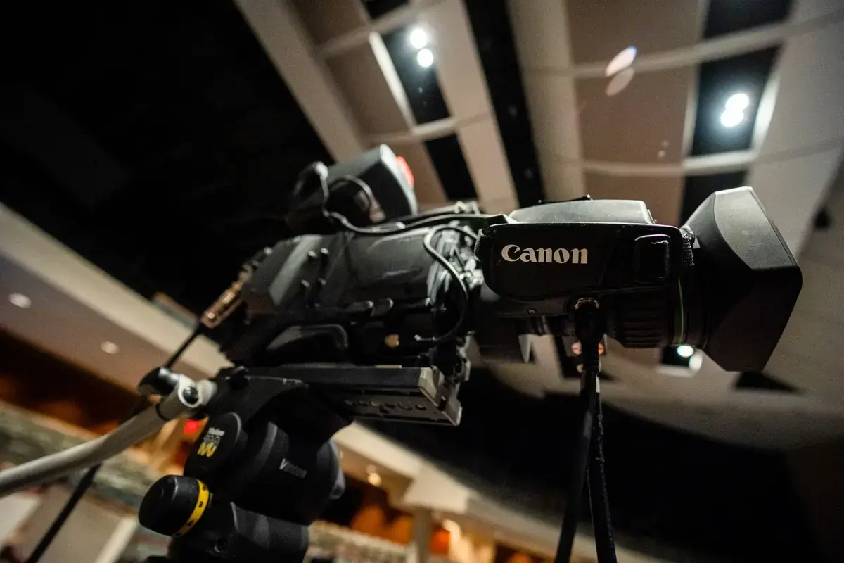 From below of professional black video camera for filming video placed in modern room