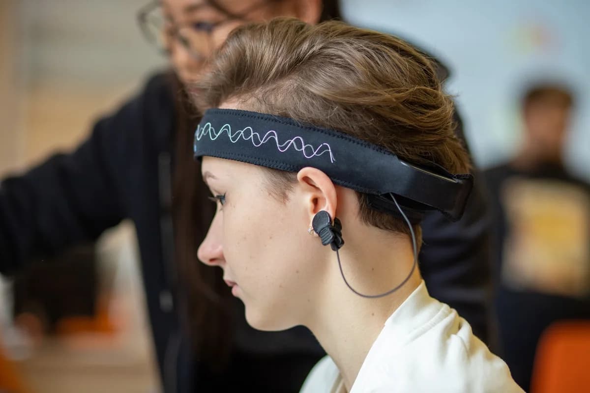 Young woman wearing an EEG headband indoors.