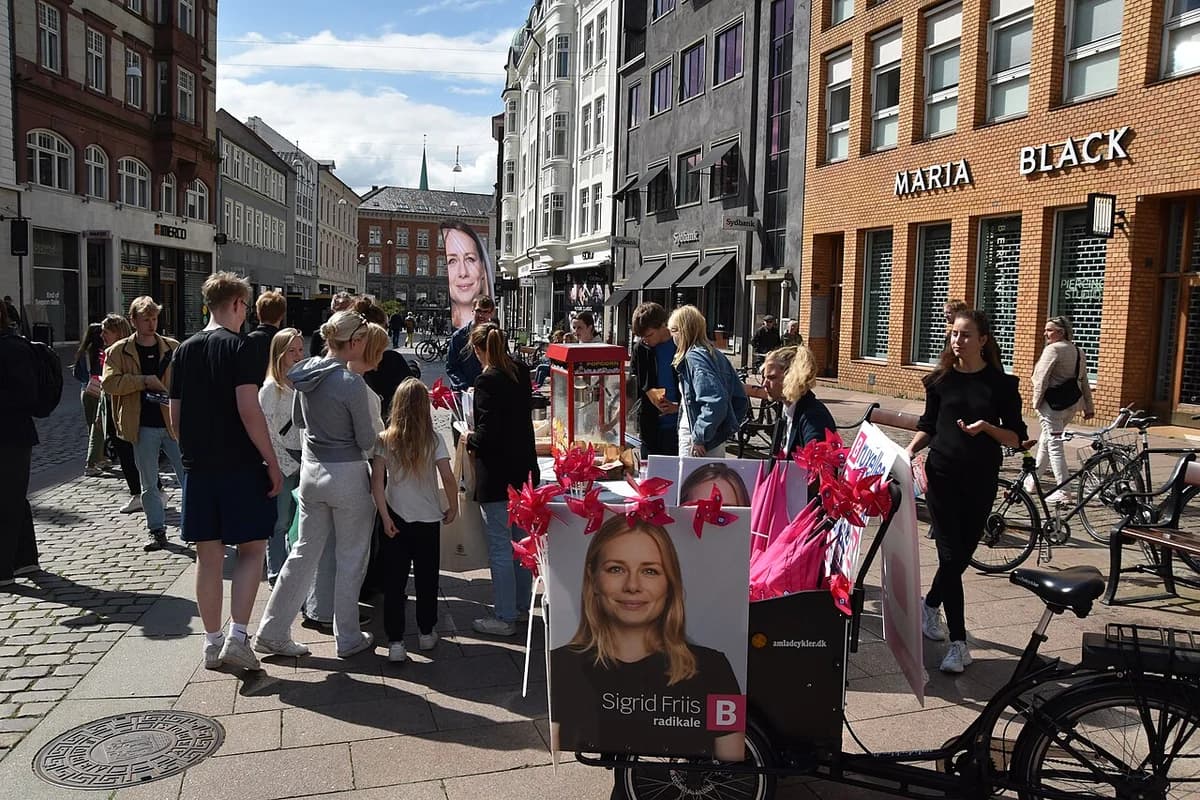 People campaigning with Radikale Venstre posters on a cobblestone street