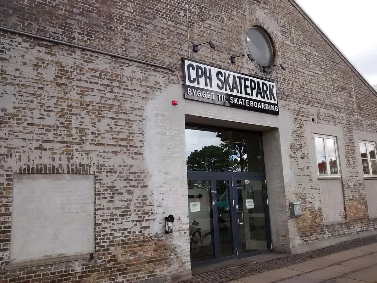 Entrance to Copenhagen Skatepark with a large sign on a brick building.