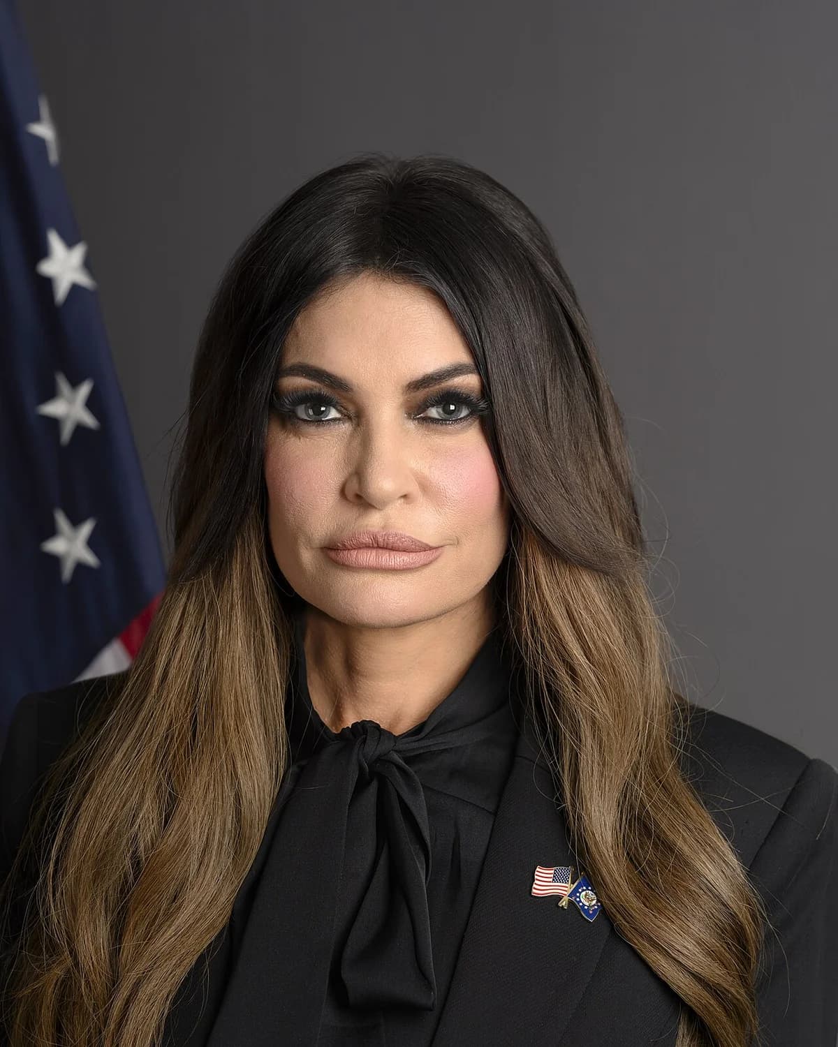 Official portrait of Kimberly Guilfoyle in front of an American flag.
