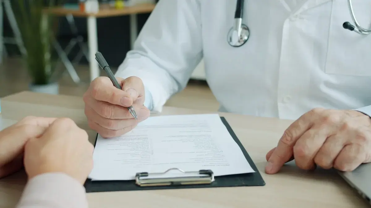 Doctor and patient reviewing paperwork during a consultation.