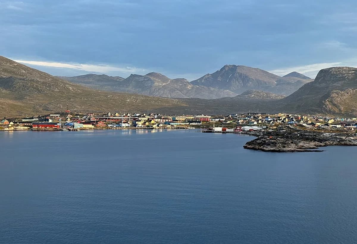Coastal town of Nanortalik, Greenland, with mountains and water.