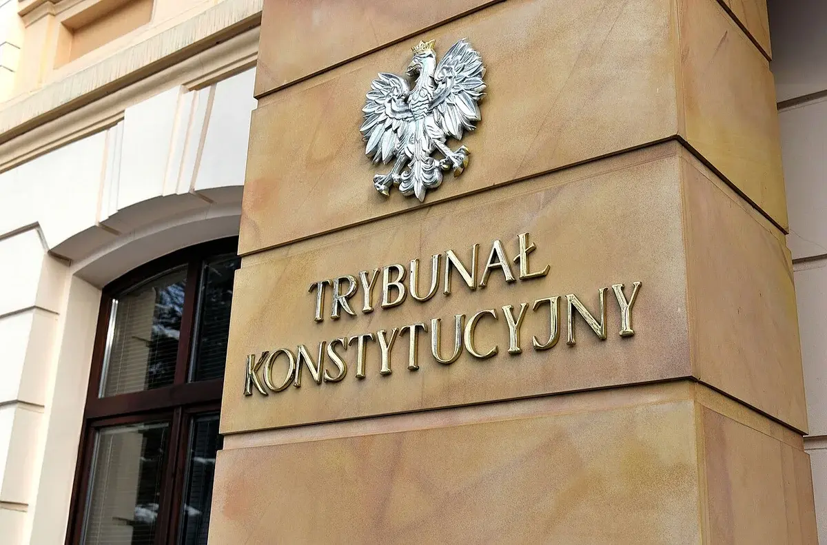 Entrance to the Polish Constitutional Tribunal building with the national emblem and Polish text on the wall.