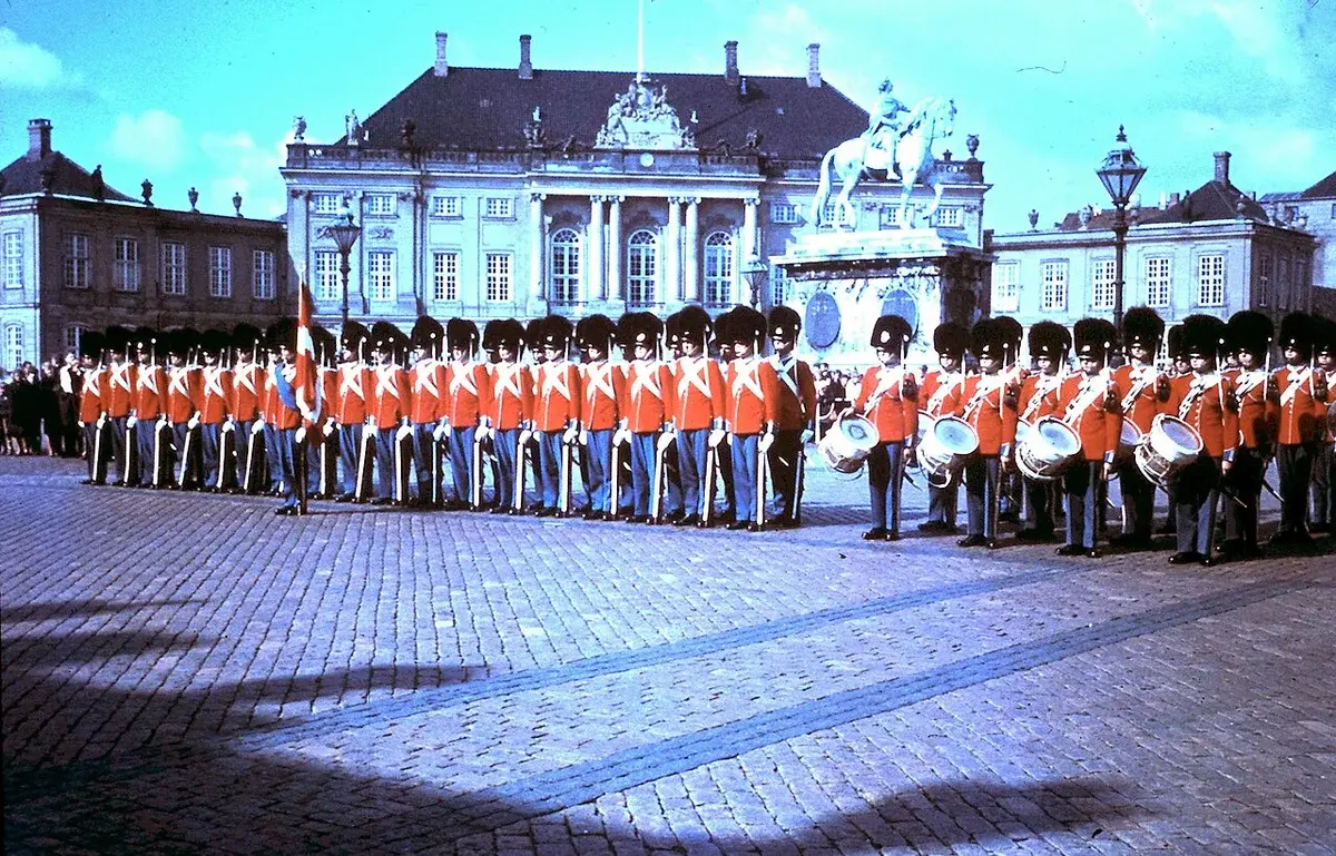 Royal guards in red uniforms standing in formation at Amalienborg Palace.
