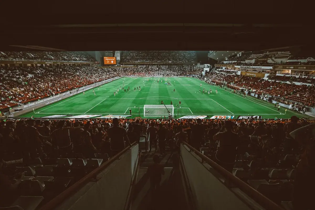 Crowded football stadium during a soccer match in Abu Dhabi.
