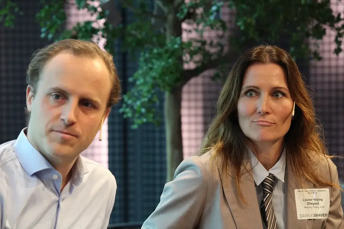 Christian Arnstedt and Louise Herping Ellegaard in conversation at a conference