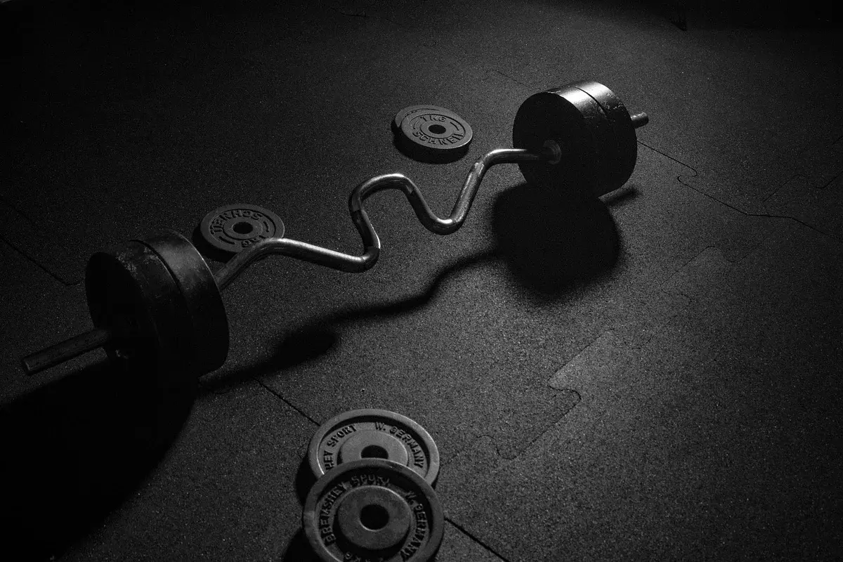 A barbell with weight plates on a gym floor.