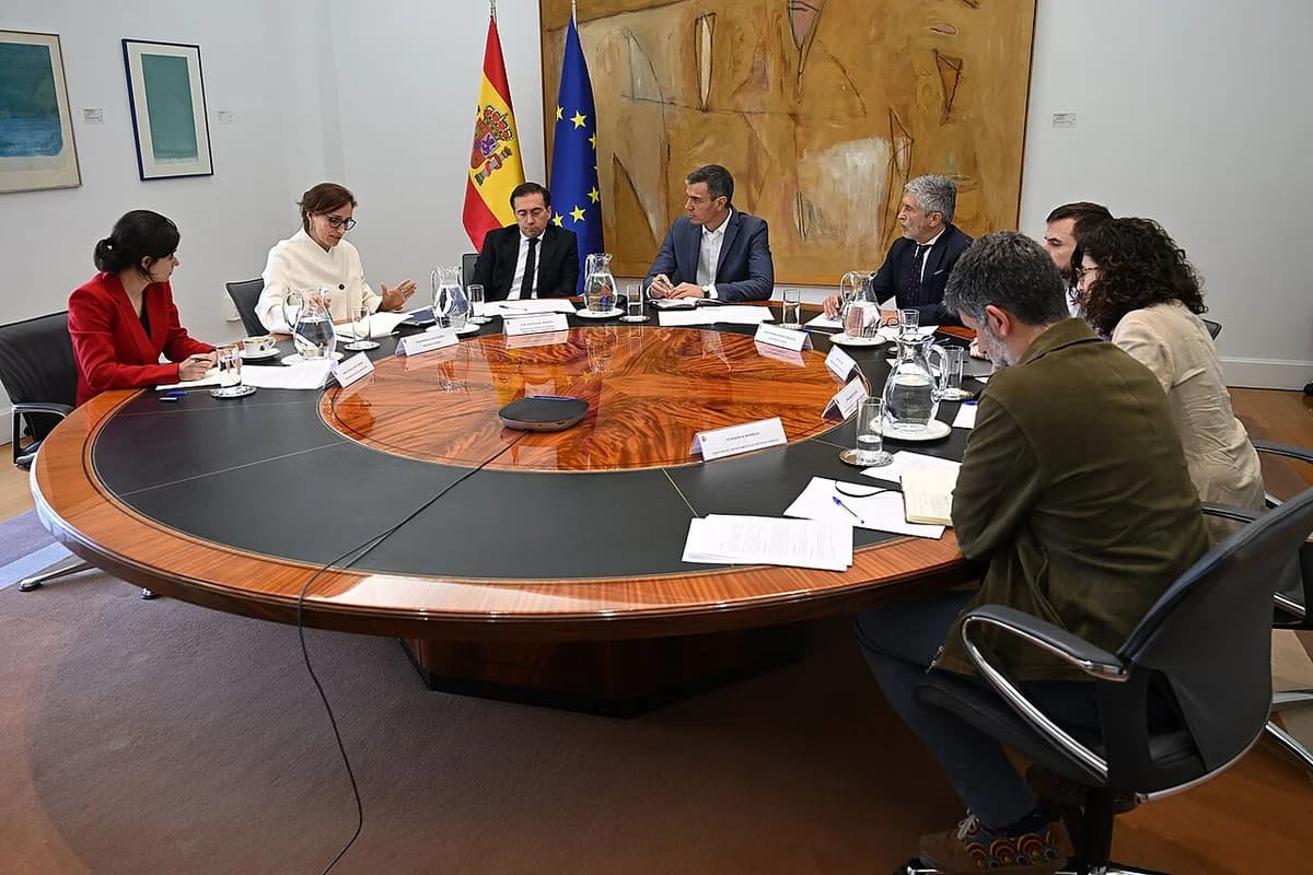 Pedro Sánchez and several officials seated around a large round conference table during a formal meeting.