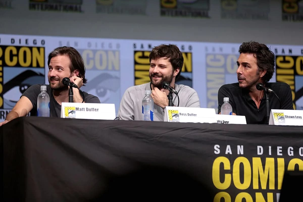 Matt Duffer, Ross Duffer, and Shawn Levy seated at a Comic-Con panel.