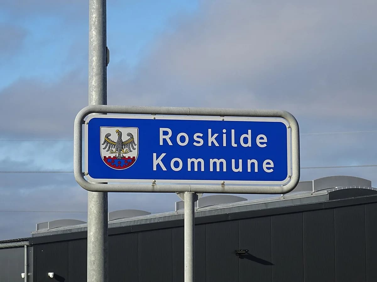 Roskilde Kommune road sign with coat of arms on a pole