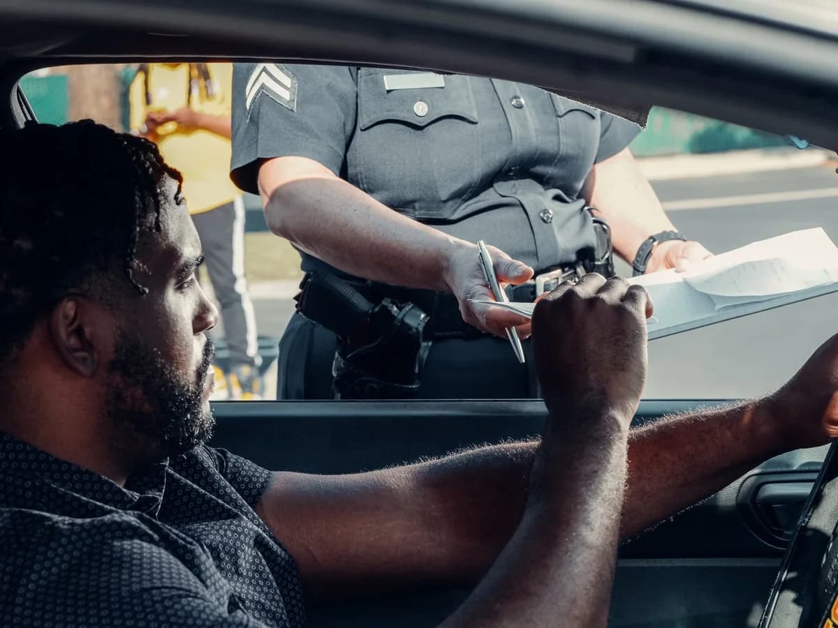 Police officer giving a traffic ticket to driver at roadside