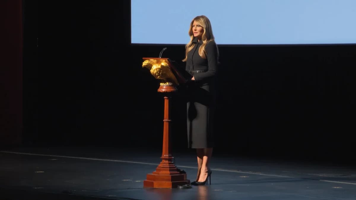 Melania Trump speaking at a podium on stage.