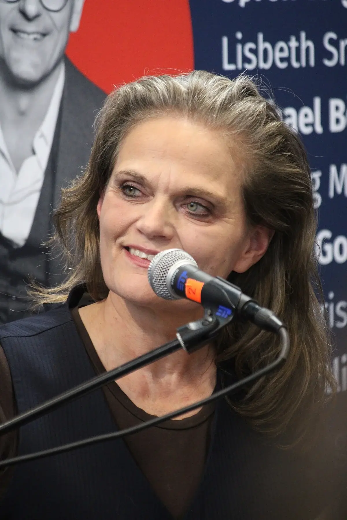 A woman speaks into a microphone at an event.