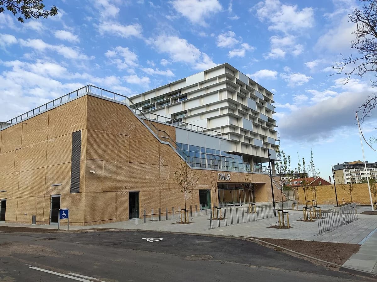 Modern DMJX building in Aarhus under a blue sky.