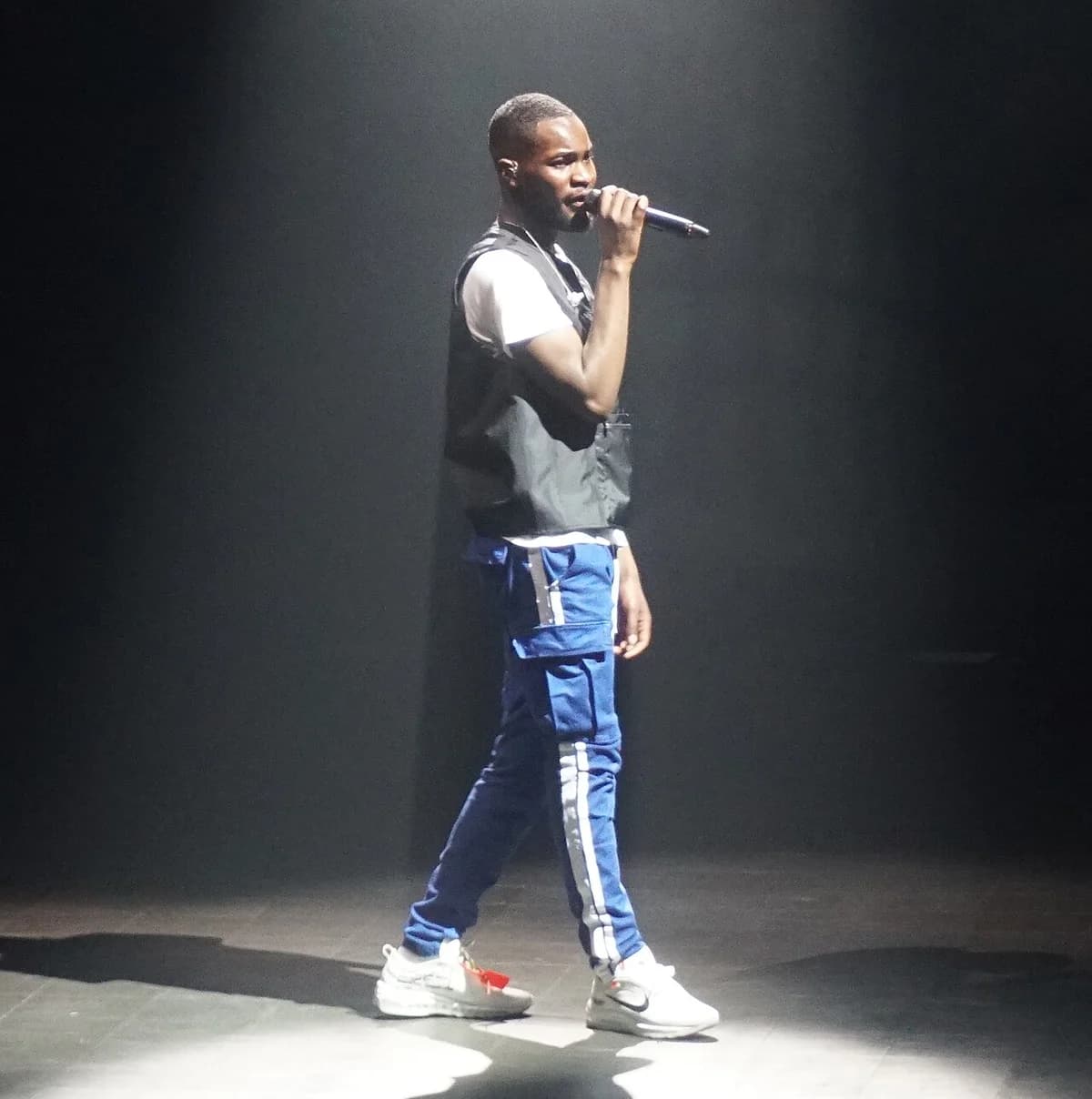 Male performer singing on stage with microphone