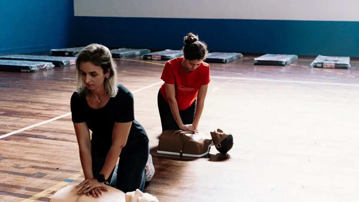 Two women performing CPR on training mannequins