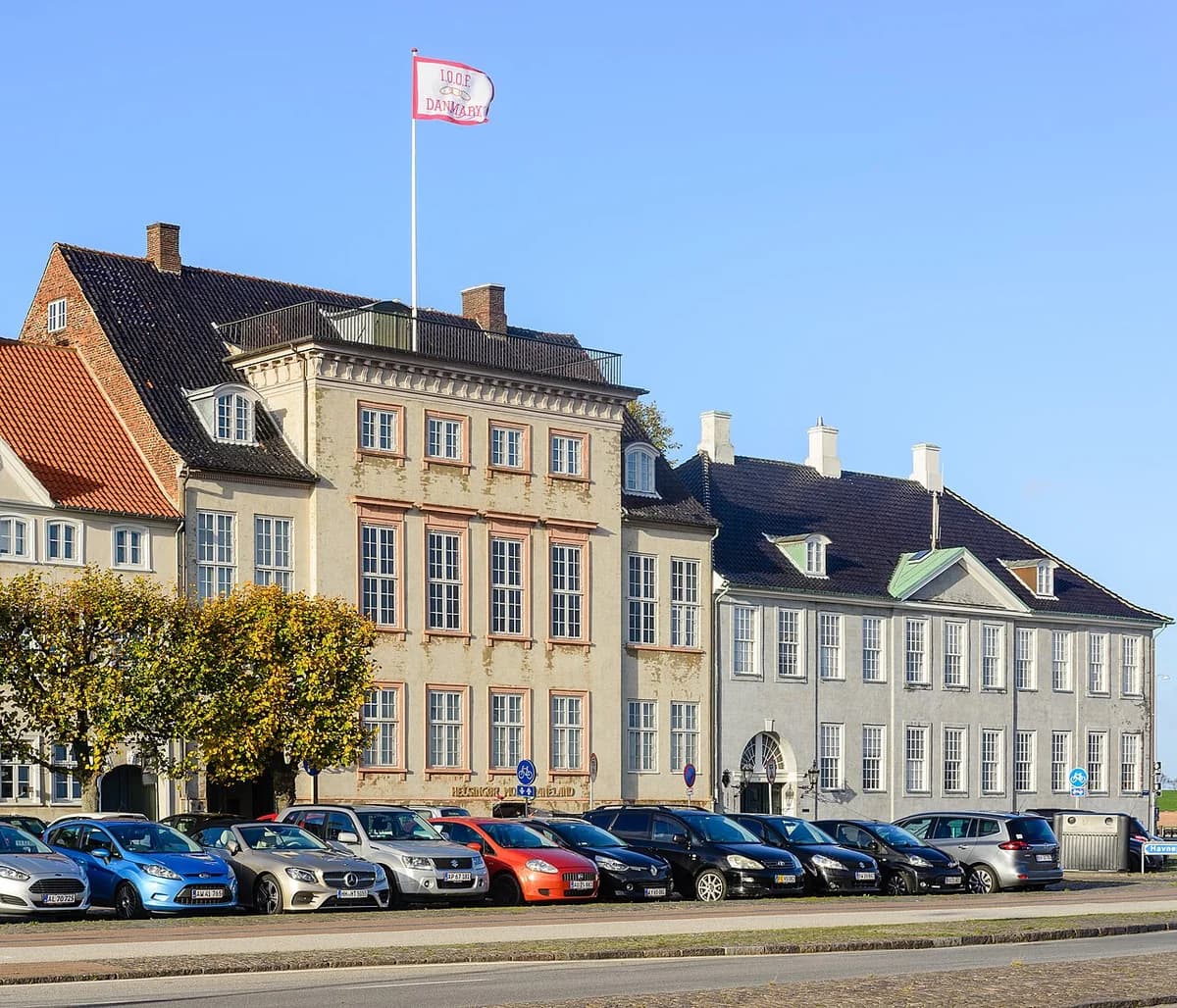 Historic buildings in Helsingør with parked cars in front.