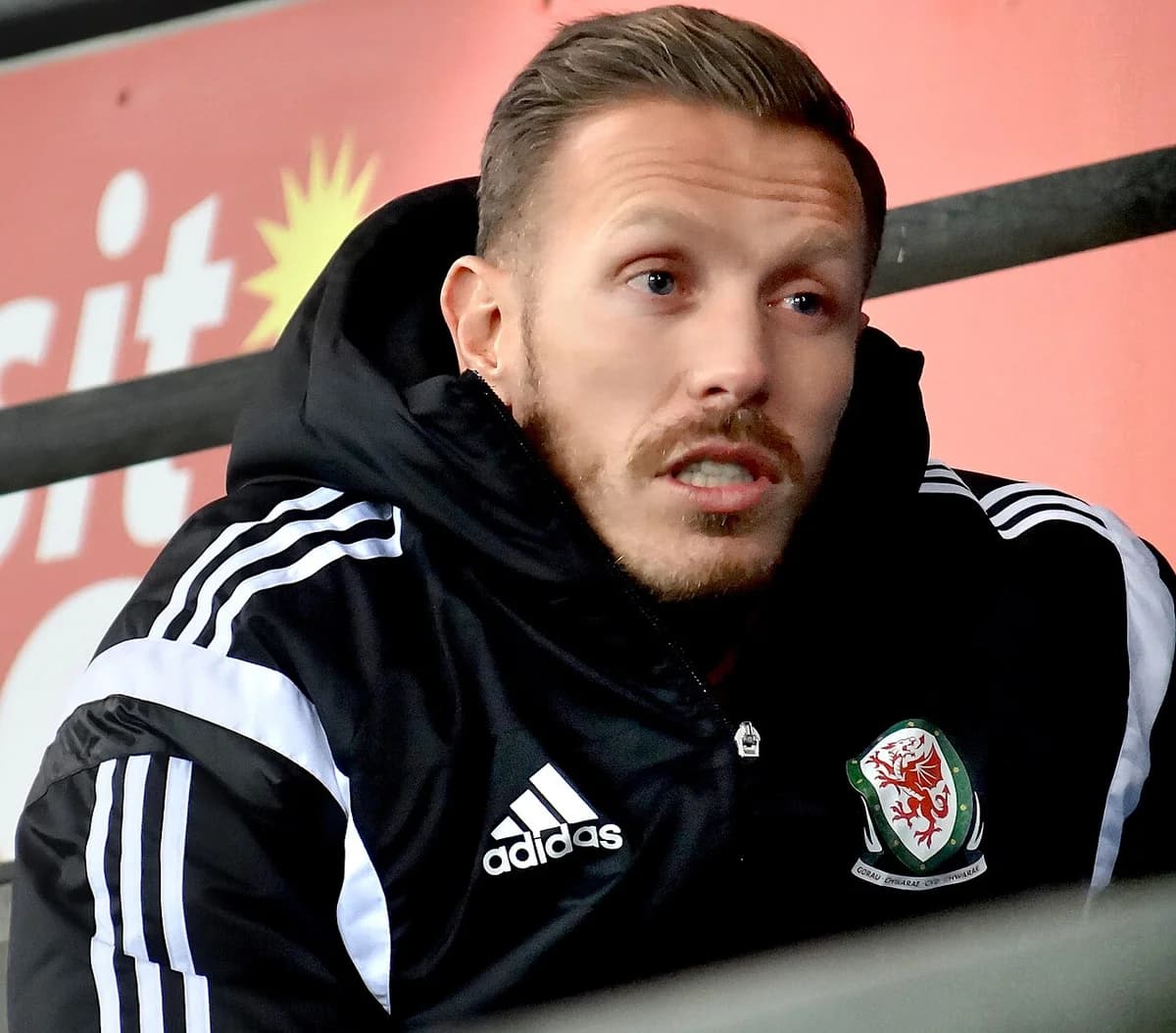 Portrait of Craig Bellamy wearing a black Wales Adidas jacket.