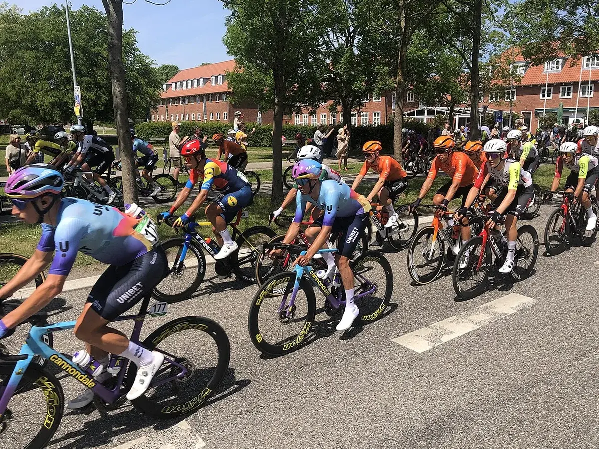 Group of cyclists riding closely on a paved road during a race