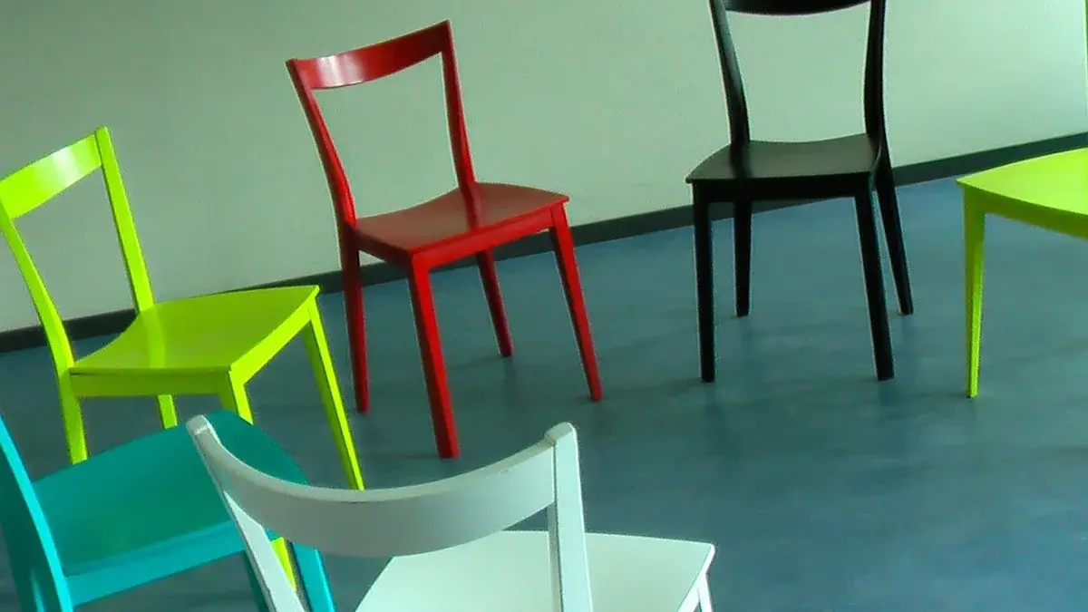 Colorful chairs arranged in a circle in an empty room.