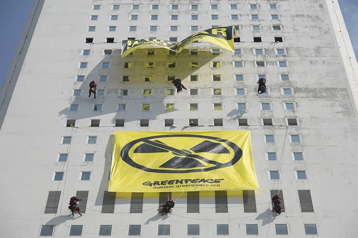 Activists hanging Greenpeace banners on building