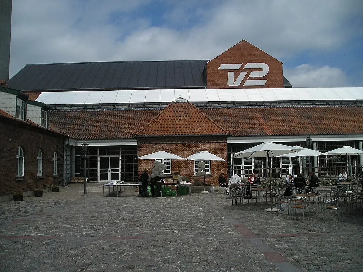 Exterior of the TV 2 headquarters building in Odense with a courtyard in front.