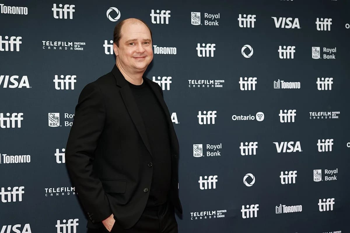 Mike Flanagan posing at TIFF 2024 in front of a branded backdrop.
