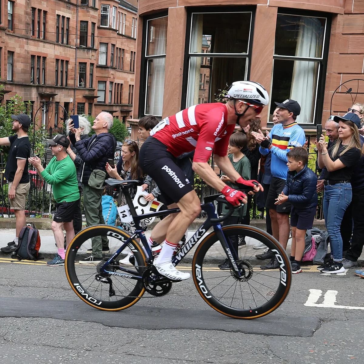 A Danish cyclist racing uphill past spectators at the UCI Road World Championships in Glasgow.