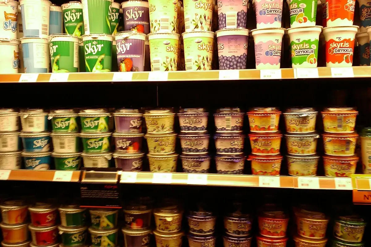Supermarket shelves filled with assorted Skyr dairy products in different flavors.