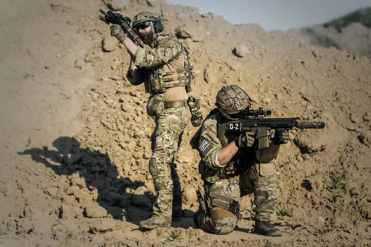 Two camouflaged soldiers training in desert with rifles