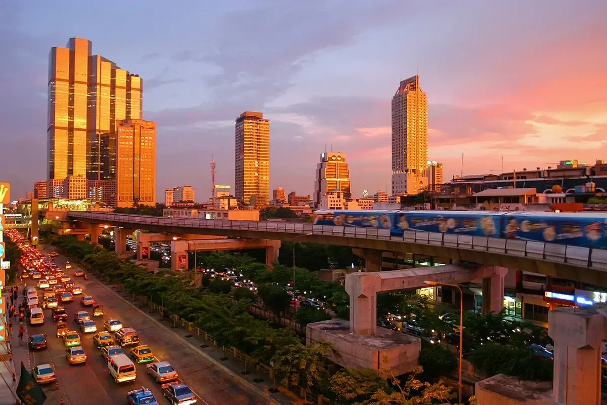 city skyline at sunset with traffic and elevated train
