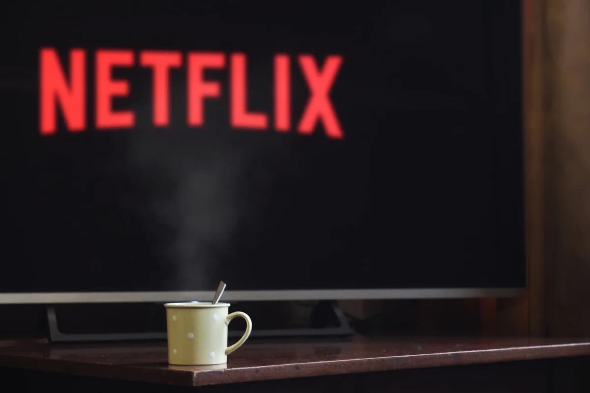Steaming cup on table in front of TV showing Netflix logo