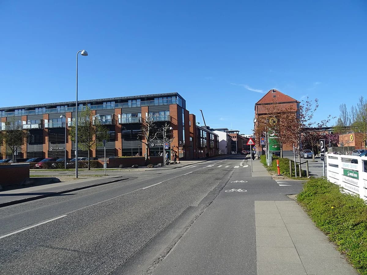 A quiet street in Vejle with modern buildings and a bike lane.